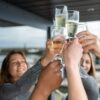 Group of friends clinking champagne glasses in an outdoor celebration.